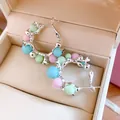 Vue détaillée de boucles d'oreilles créoles à perles colorées dans un écrin à bijoux chic. - Rose Bleu Vert
