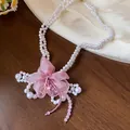 Detailed close-up of the delicate pink chiffon flower on this pearl beaded necklace - Necklace / White-Purple