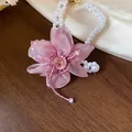 Close-up detail of the elegant pink chiffon flower and pearl beaded necklace set - Bracelet / White-Purple