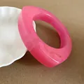 Macro view of a stylish pink resin bangle with unique irregular geometric design - Pink