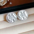 Close-up of vintage matte silver stud earrings with embossed floral pattern detail - Round Printed Style (HE32188) / Silver
