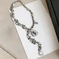 Detail showing rhinestone money bag pendant and pearl tassel on a long silver necklace. - Money Bag Abacus Pearl Tassel Style / Silver