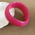 Close-up of a thick magenta resin bangle with elegant white marbled patterns - Rose Red