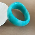 Macro view of a turquoise irregular resin bangle featuring a smooth geometric design - Cyan