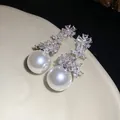 Detailed view of zircon flower and pearl drop earrings with elegant silver finish - Silver