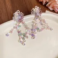 Close-up of dopamine style flower earrings with iridescent sequin tassels - Flower Tassel Style (Silver Post) / White-Purple