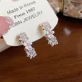 Dettaglio ravvicinato di orecchini a C con fiori rosa, zirconi e finitura in argento - Orecchini a fiore a forma di C / Rosa