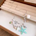Detailed view of summer starfish and shell charm necklace with white pearls and resin charms - Choker Necklace / Green