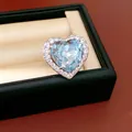 Detailed close-up of heart-shaped ring with light blue zircon and surrounding halo stones - Heart Open Ring / Blue