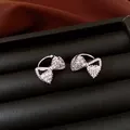 Detailaufnahme funkelnder Zirkon-Schleifen-Ohrklemmen in schwarzem Schmucketui. - Schleife Stil (HE34019) / Silber