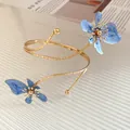 Gros plan détaillé d'un bracelet de bras spirale doré avec fleurs en émail bleu - Bracelet de Bras Ouvert Fleur (HB5663) / Or-Bleu