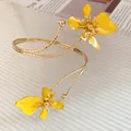 Vue détaillée d'un élégant bracelet de bras en métal doré avec fleurs en émail jaune. - Bracelet de Bras Ouvert Fleur (HB5663) / Or-Jaune