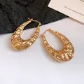 Dettaglio degli orecchini a cerchio in metallo dorato a forma di U con texture vintage - Orecchino a cerchio martellato a forma di U (HE33248) / Oro