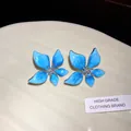 Detailed macro view of blue enamel flower earrings with sparkling rhinestone centers - 3 Silver Post - Blue