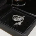 Macro di un anello a piuma color argento con pietre di zircone in una scatola da regalo - Design a Piuma / Argento