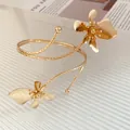 Gros plan d'un bracelet de bras doré en spirale avec des fleurs au fini mat - Bracelet de Bras Ouvert Fleur (HB5663) / Or