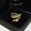 Primo piano di un anello a piuma placcato oro 18K con pietre di zirconia - Design a Piuma / Oro