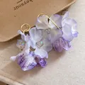 Close-up of delicate purple fabric flower earrings with iridescent crystal beads - Purple