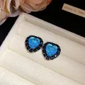 Detail van hartvormige blauwe zirkoon oorbellen met zwarte stenen halo in een doos. - Hartvorm (Blauw) / Gunmetal