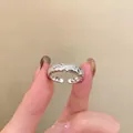 Detailed view of an adjustable silver-colored twisted rope ring featuring sparkling zircon stones - Twisted Texture Style / Silver