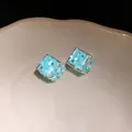 Dettaglio di orecchini a cubo con trama in conchiglia blu e piccoli cristalli - Blu