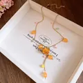 Detail view of handmade resin necklace with preserved orange rose and beads - Yellow Rose / Gold