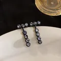Detailed view of elegant black geometric stud earrings set with round clear zircons - T-Shape Dangle Style (HE33293) / Black
