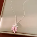 Primo piano della collana con ciondolo a fiocco rosa in smalto e fiori in zirconi. - Argento-Rosa