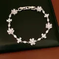 Macro detail of the sparkling cubic zirconia flower and cross links on a silver bracelet. - Patchwork Flower Style / Silver and White