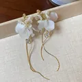Close-up of elegant white frosted flower earrings with long gold curved tassel details - Flower Tassel Style (HE31387) / Silver Pin-Gold-White