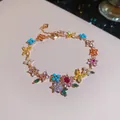 Primer plano de una pulsera chapada en oro con flores de circón de colores. - Dorado-Multicolor