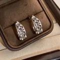 Detailed macro view of silver filigree C-shaped earrings with pearls in a brown jewelry box - C-Shaped Hollow Pearl Studs / Light Coffee Gold