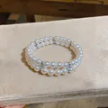 Close-up of elegant double-layered pearl bracelet with crystal spacers on velvet display - Silver-White