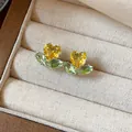 Macro detail of 18k gold plated flower earrings with heart-shaped yellow zircons - Style 4 (HE31331)