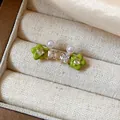 Close-up of green flower stud earrings with zirconia and pearls in a jewelry box - Style 5 (HE31331)