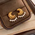 Detailed view of vintage golden crescent earrings with elegant pearl tassel charms. - Gold