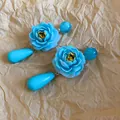 Detailansicht blauer Rosen-Ohrhänger im Vintage-Palast-Stil auf Papierhintergrund. - Anhänger-Stil / Blau