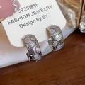 Macro view of 18k gold plated C-shaped earrings with honeycomb zircon details - Silver