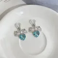 Detailed close-up of elegant bow heart clip-on earrings with pearl and blue crystal drops - Ear Clip - Silver - Blue