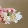 Close-up detail shot of sweet white mesh flower earrings with green crystal beads and rose studs - Mesh Large Flower Style