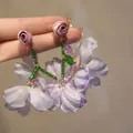 Close-up of lilac mesh flower earrings with crystal beads and rose stud detail - Mesh Tassel Style