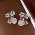 Macro shot of vintage floral stud earrings with pink, green, and yellow cubic zirconia stones. - Silver-Pink-Yellow-Green