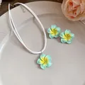 Gedetailleerde close-up van Hawaiiaanse muntgroene plumeria bloem ketting en oorbellen. - Ketting en oorbellen set / Groen
