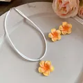 Detailansicht der gelben Frangipani-Blumen-Halskette und des passenden Ohrring-Sets - Halskette und Ohrringe Set / Orange