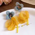 Close-up detail of romantic yellow chiffon flower tassel earrings with blue lace accents - Silver Earring Post Style / Yellow