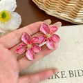 Orecchini a lobo a fiore in smalto rosa vibrante con elegante bordo dorato. - Rosa