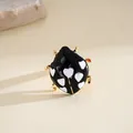 Vista macro dettagliata di un anello a coccinella in smalto nero con cuori bianchi - Oro-Nero