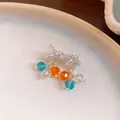 Gros plan détaillé de boucles d'oreilles étoile de mer avec perles de cristal colorées. - Boucles d'oreilles (Tige en argent) / Argent-Bleu