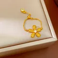 Détail d'une bague à chaîne réglable dorée avec un charm de fleur en cristal brillant - Jaune
