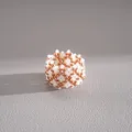 Detailed macro view of a handmade woven ring featuring rose gold and white beads - Ring / Gold-White